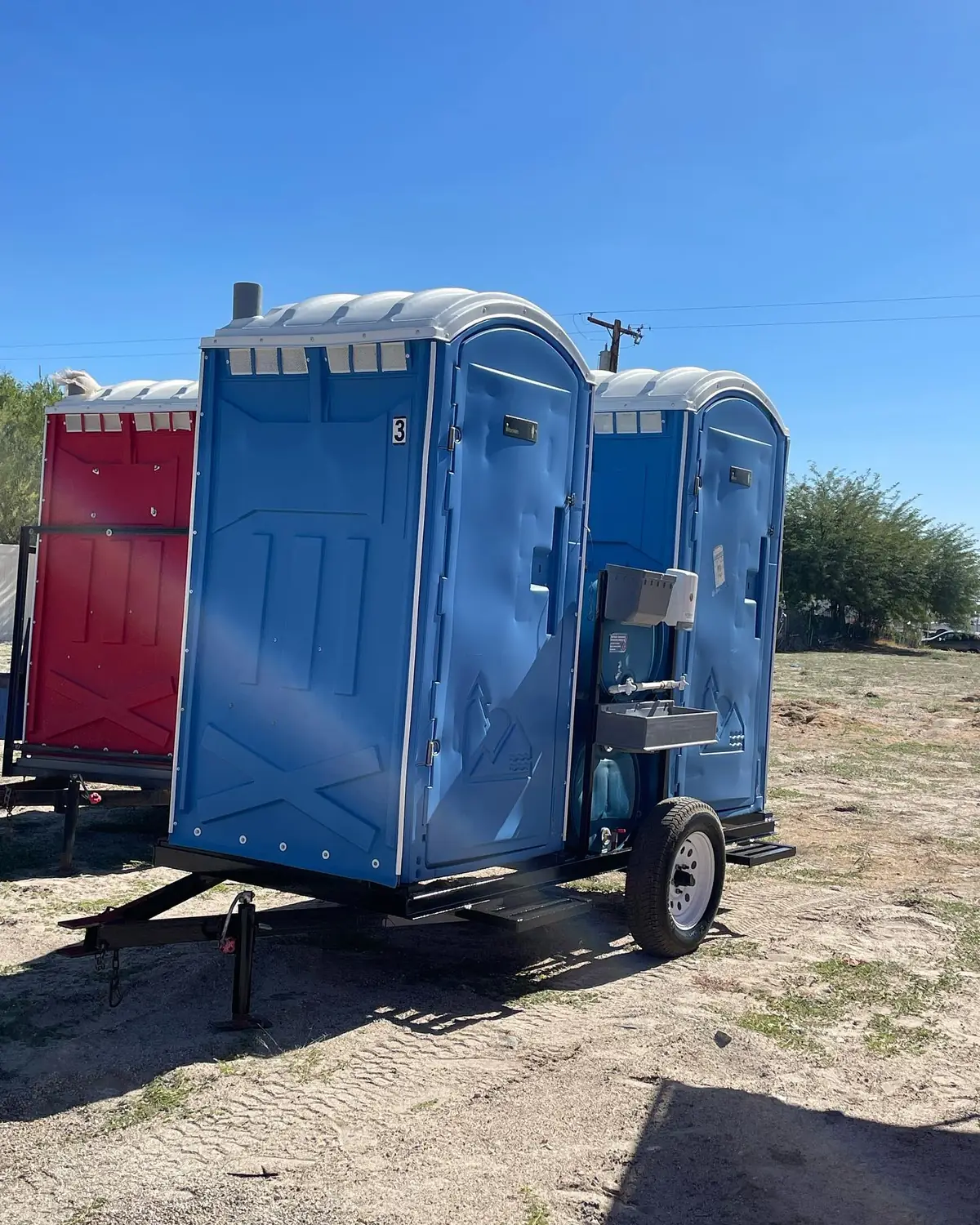 Porta potties strapped on a delivery trailer