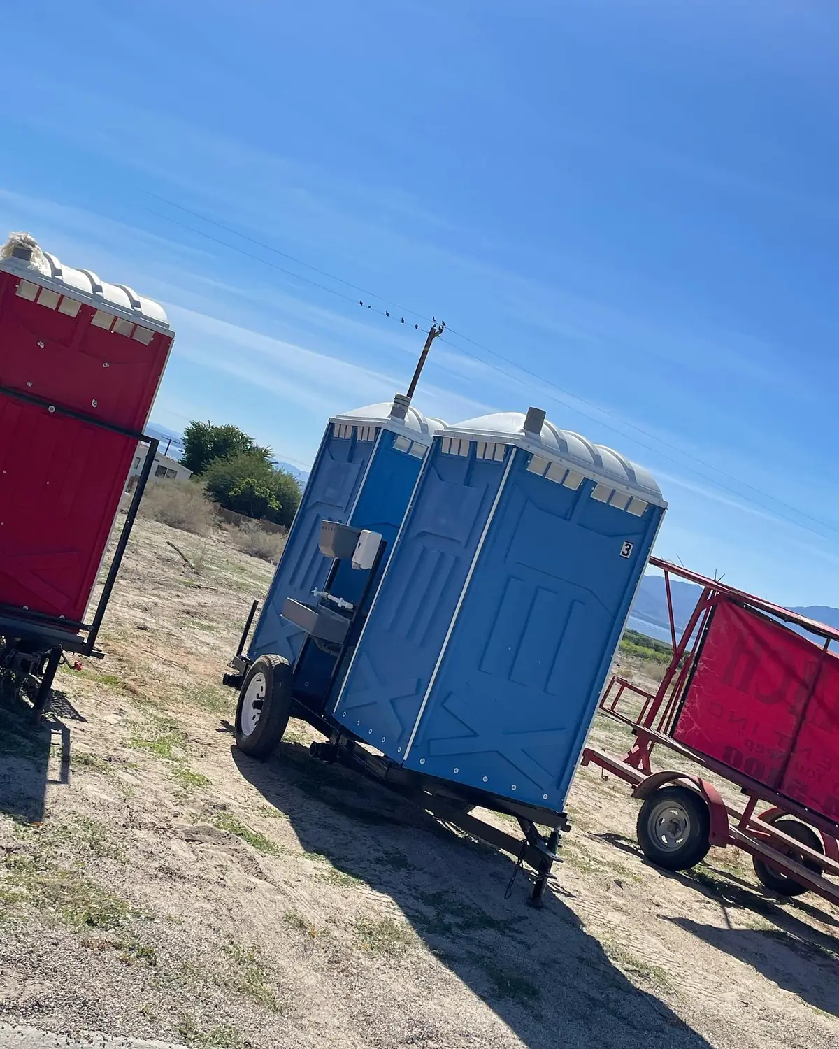 Porta potties on a delivery trailer parked at a jobsite