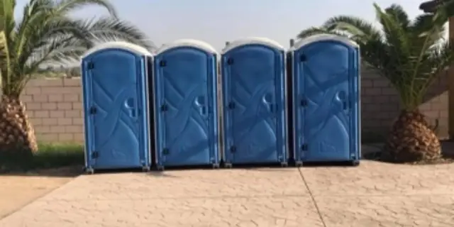 Row of blue porta potties set up for an outdoor event