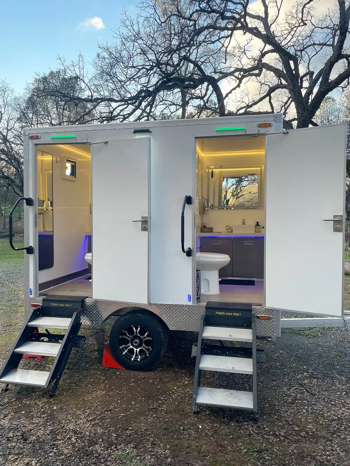 Two-stall restroom trailer with its lights on
