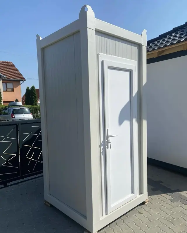 Side view of a white VIP restroom unit next to a patio